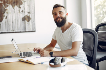 Students create a new project. Guy learning and use the laptop. Man in a white t-shirt