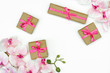 flatlay of Gift present boxes with pink ribbon, orchid flowers on white background. spring concept. Copy space