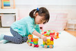 © M-image - toddler girl playing creative toy blocks at home against white background