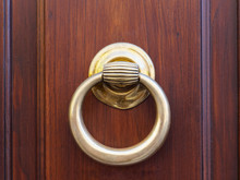 Old Knocker Ring Made Of Brass On A Wooden Door