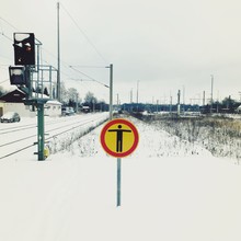 No Trespassing Sign On Snowy Landscape By Railroad Tracks