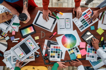 Wall Mural - working on a new project together. top view of designers discussing sketches, choosing colors from p