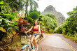 © Adam Hester - A young girl riding her bicycle on a rural road in a tropical area of Kauai in Hawaii.