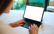 © Farknot Architect - Mockup image of a woman using and typing on tablet pc with blank white desktop screen as computer pc while lying down on a cozy white bed at home