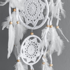 Wall Mural - White crocheted dreamcatcher, an Indian amulet that protects the sleeper from evil spirits and diseases. Soft focus. Closeup.