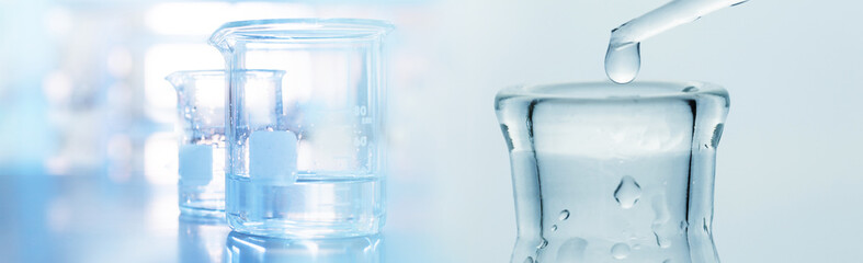 Wall Mural - water drop into research glass flask and beaker in medical science laboratory banner background