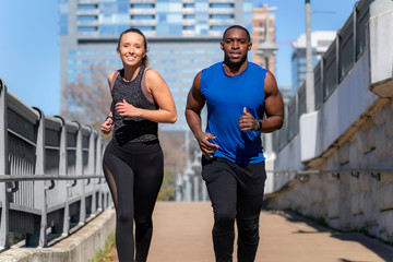 A young fit healthy lifestyle living modern couple exercising in urban city, street workout, free running, downtown