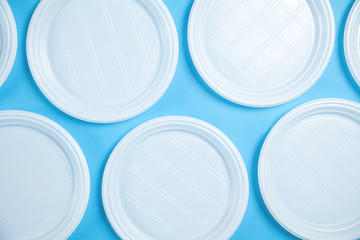 White plastic plates blue background.