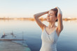 © pavelvozmischev - Summer Sunny walk along the beach. Emotional beautiful girl at sunset on the pier.