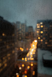 Fototapeta Tęcza - City of Chicago background image of gloomy weather and raindrops on a glass window in focus with the street and lights out of focus with soft bokeh.