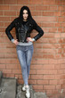 © Вячеслав Чичаев - Full-length portrait in spring weather outdoors, caucasian brunette girl in jeans and a black jacket with a great figure. Model posing against the backdrop of a building wall.
