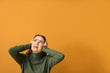 Young woman suffering from loud noise on color background