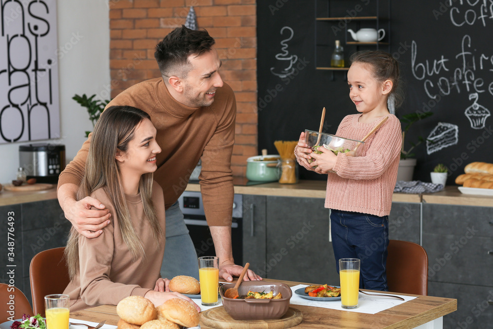 Happy family having dinner together in kitchen