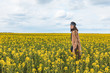 © phpetrunina14 - young pretty smiling woman walking in yellow rapeseed field