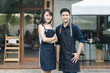 © Kris Tan - Business owners standing at entrance of newly opened restaurant and preparing to serve aclient.