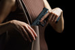 Woman hand pulling a pistol out of handbag on black background.