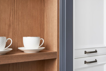 white English tea cups on the kitchen shelf