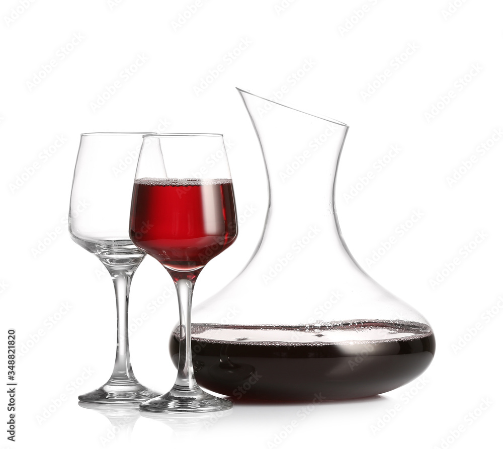 Decanter of wine and glasses on white background