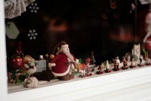 Figurines On Window Sill Seen From Glass
