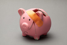 Broken Piggy Bank With Band-aid On Gray Background