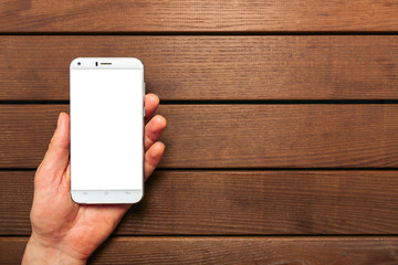 A top view of a set of wired earbud headphones and mobile phone blank template lying on a rustic wooden table. mockup image