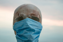 Medical Mask On The Skull. Against The Sky And The City Protection From Covid-19