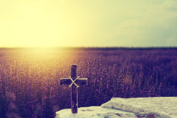 Sticker - Wooden Christian cross on rocks against beautiful golden sunrise over lavender field
