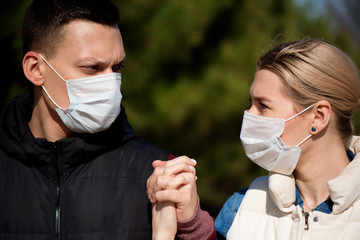 Friends in face masks walk in the park for fear of becoming infected with coronavirus.