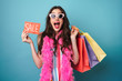 © Drobot Dean - Image of delighted woman in boa holding sale card and shopping bags