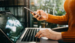 © ARMMY PICCA - businesswoman hand using smart phone, tablet payments and holding credit card online shopping, omni channel, digital tablet docking keyboard computer at office in sun light