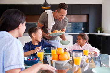 Wall Mural - Hispanic Family Sitting Around Table Eating Breakfast Together