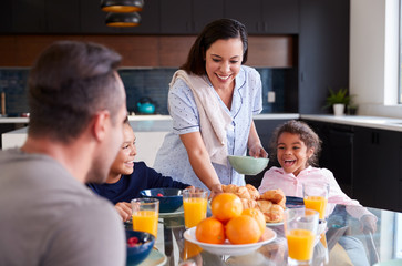 Wall Mural - Hispanic Family Sitting Around Table Eating Breakfast Together