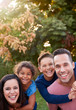 © Monkey Business - Portrait Of Smiling Hispanic Family With Parents Giving Children Piggyback Rides In Garden At Home