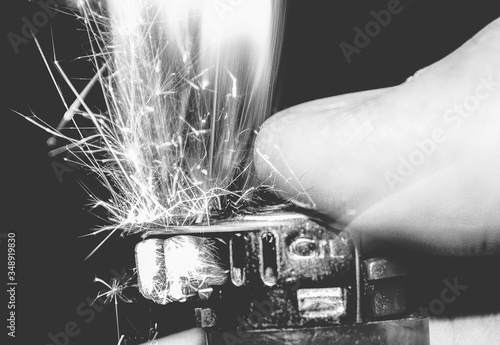 Fotomural Cropped Image Of Hand Igniting Cigarette Lighter In Darkroom