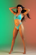 © master1305 - Fashion portrait of young fit and sportive caucasian woman in stylish blue swimwear on gradient background. Brunette longhair model. Perfect body ready for summertime. Beauty, resort, sport concept.