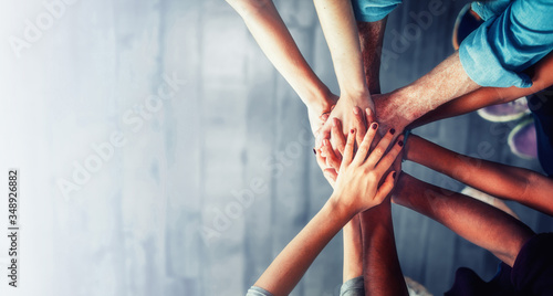 Fotomural Close up top view of young business people putting their hands together