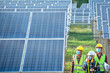 © เลิศลักษณ์ ทิพชัย - A team of engineers and three Asian architects walked to visit the solar panel. Engineering team wearing medical masks to protect the corona virus (Covid-19). Asian engineers look at solar panels.
