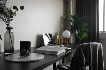 Wall Mural - Bedroom working corner decorated with laptop, white candles and artificial plant in glass vase on black wood  working table with beige painted wall in the background /apartment interior / copy space