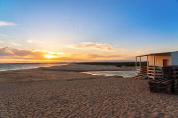 Wall Mural - Landscape of a beautiful sunset on the ocean, with a horizon with a blue sky and a house on the sand. Portugal.