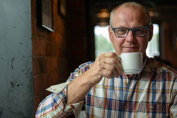 Portrait of senior businessman drinking coffee at the coffee shop