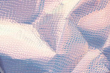 Wall Mural - Blurred light rainbow crumpled holographic background with a reptile skin texture in blue toned.