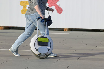 people go with an electric monowheel to the shopping center