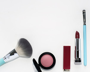 Wall Mural - Bright decorative cosmetics: pink lipstick, cosmetic brush, pink blush on a white background.