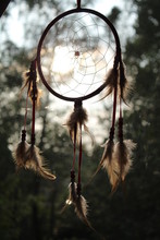 A Red Dream Catcher With A Lot Of Light's Feathers 