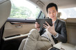 © komgritch - Handsome asian businessman working with tablet. Young executive manager Full concentration at work while sitting in the car.