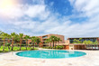 © sergojpg - Modern luxurious pool with clean, clear, blue water, palm trees