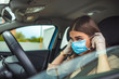 © Dragana Gordic - A young woman is putting a mask on her face, to avoid infection during flu virus outbreak and coronavirus epidemic, getting ready to go to work by car. Healthcare, virus protection
