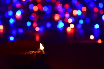 Wall Mural - Diya lamps lit with bokeh background during diwali celebration