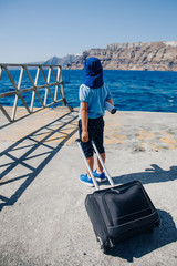 boy with luggage in a dock