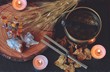 Wiccan witch altar prepared for sound healing magick with 741hz tuning fork and Tibetan singing bowl. Esoteric flat lay with dried plants, flowers, crystals, burning lit candles on a dark wooden table